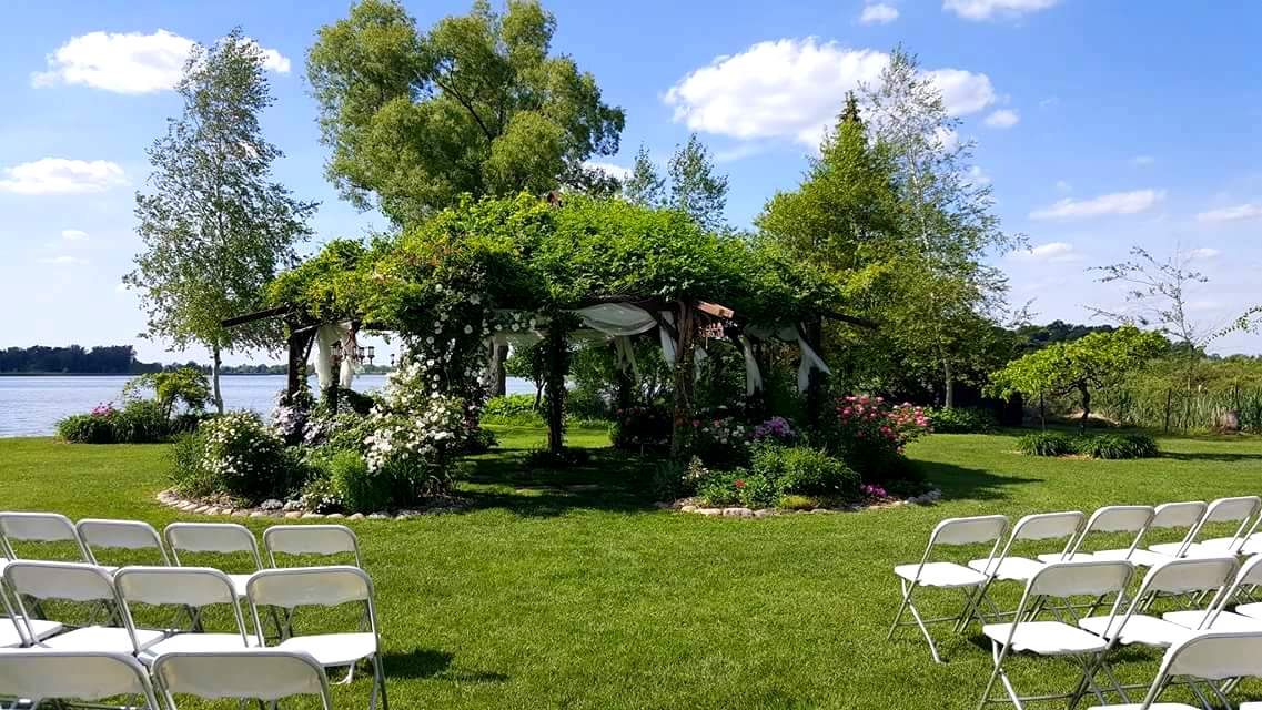 Climbing Clematis and Roses arise over other Roses and Garden Peonies